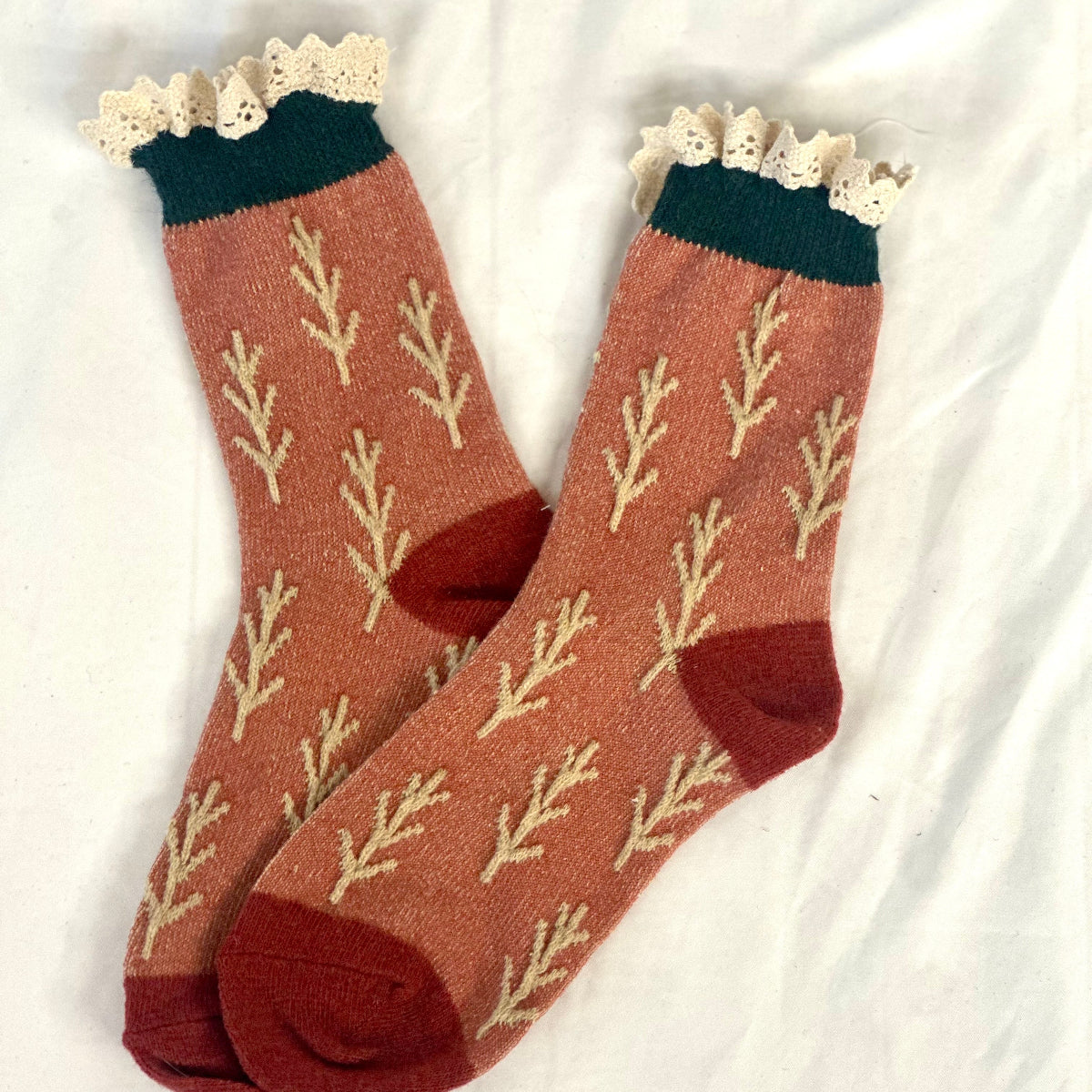 Pair of socks with leaf pattern and lace trim on a white background, TWIGS lace topped socks - rust