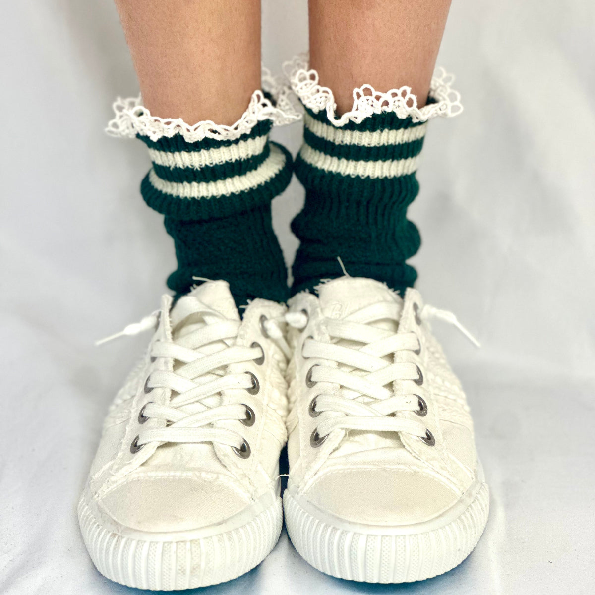 Green and white striped socks with lace trim worn with white sneakers on a light gray background, VARSITY striped crew socks - hunter green
