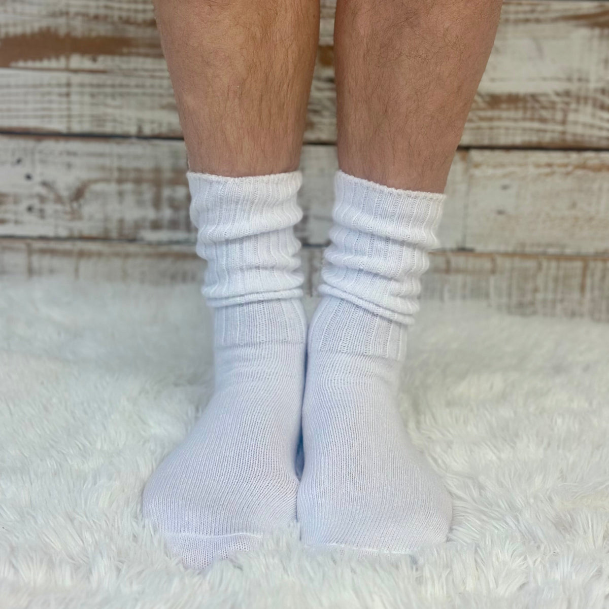 White socks worn on feet with a wooden floor background Catherine Cole