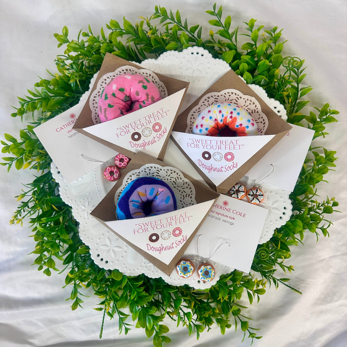 Gift set with earrings and cards on a decorative green leaf background