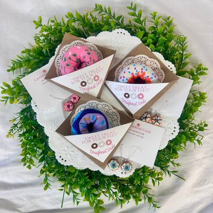 Gift set with earrings and cards on a decorative green leaf background