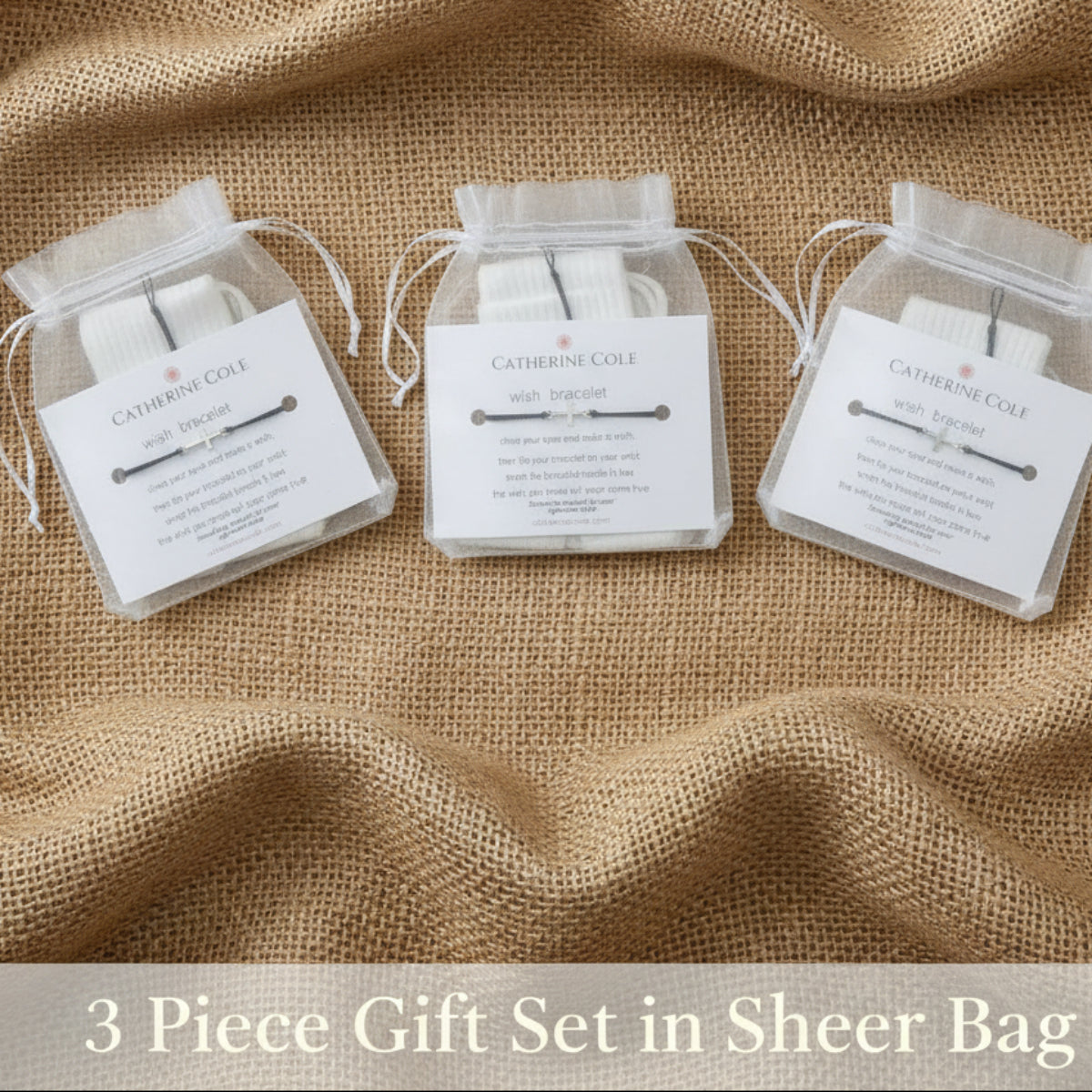 A pair of silver-toned barbell earrings in a clear plastic bag with a white paper insert card labeled 'CATHEDRAL COALE'.