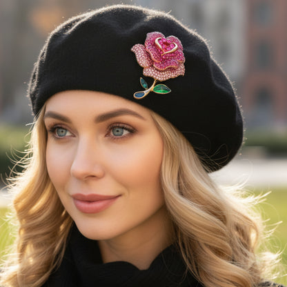 Woman wearing a black beret with a pink rose brooch, outdoors.