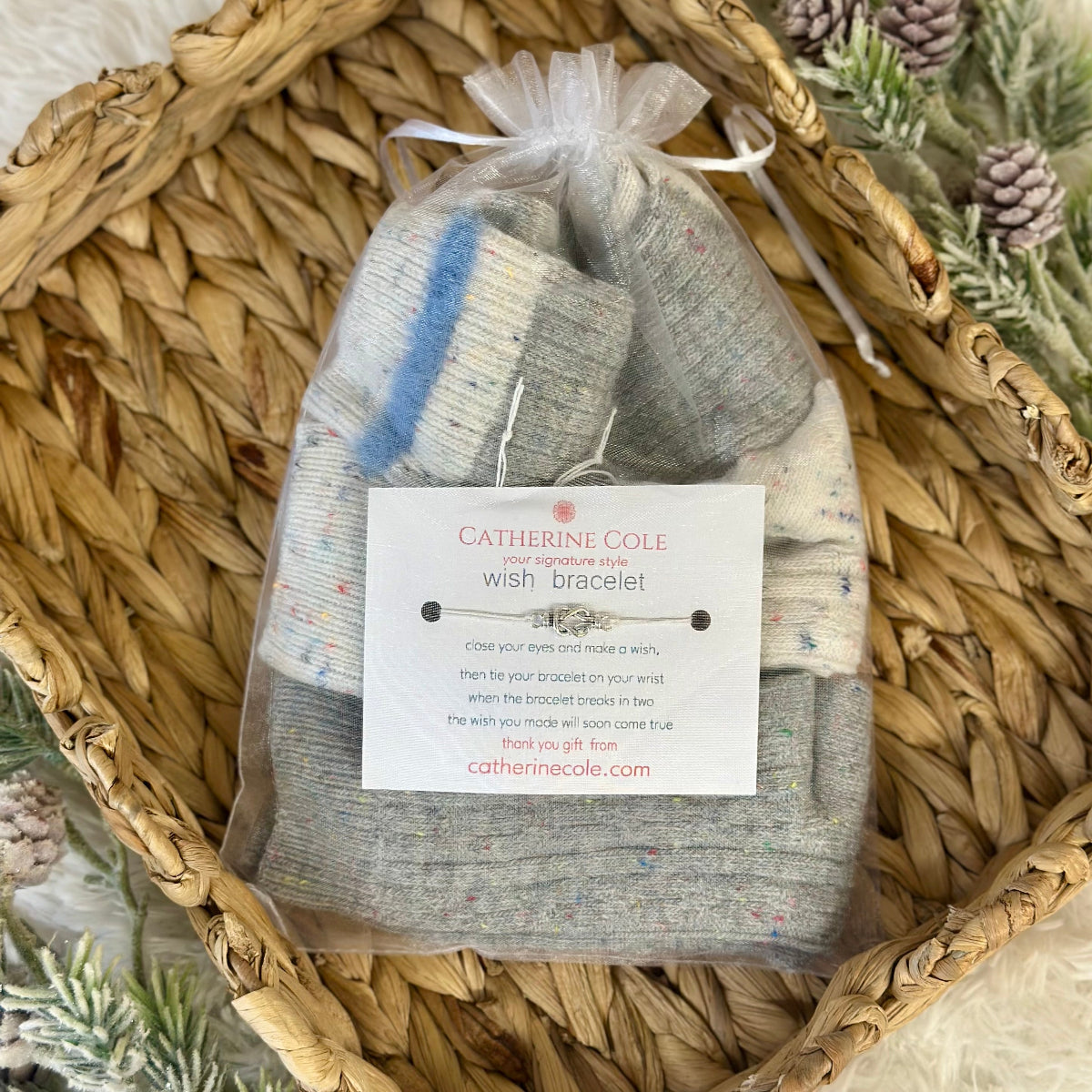 Catherine Cole wish bracelet package in a woven basket with Christmas decorations.