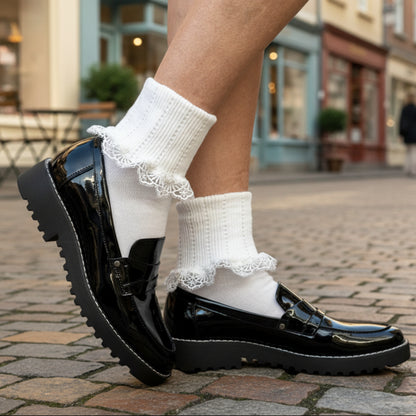 Black shoes with white socks featuring lace trim on a textured surface.  DAINTY Lace Cuff Ankle Socks - White
