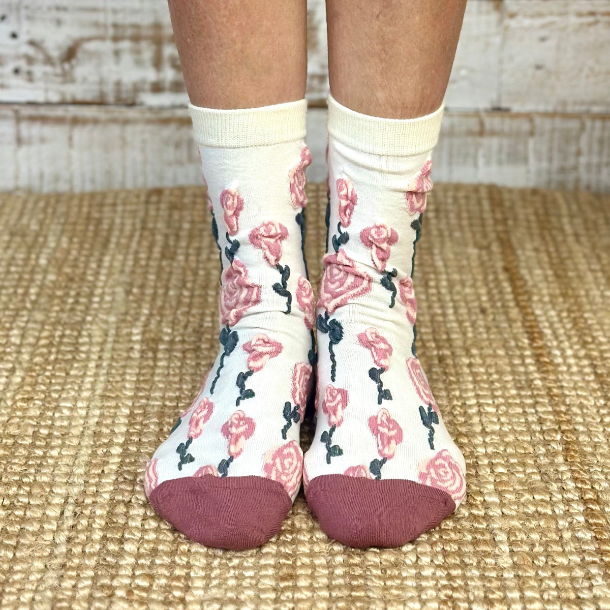 White socks with floral pattern worn on a woven mat