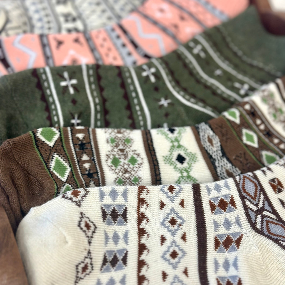 Patterned socks in various colors stacked together. 