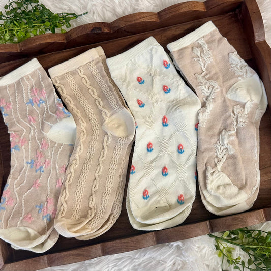 Set of five pairs of socks with floral patterns on a wooden tray.  Lightweight Summer Ankle Socks 4-Pack Bundle with Wish Bracelet - Women's 6-9 