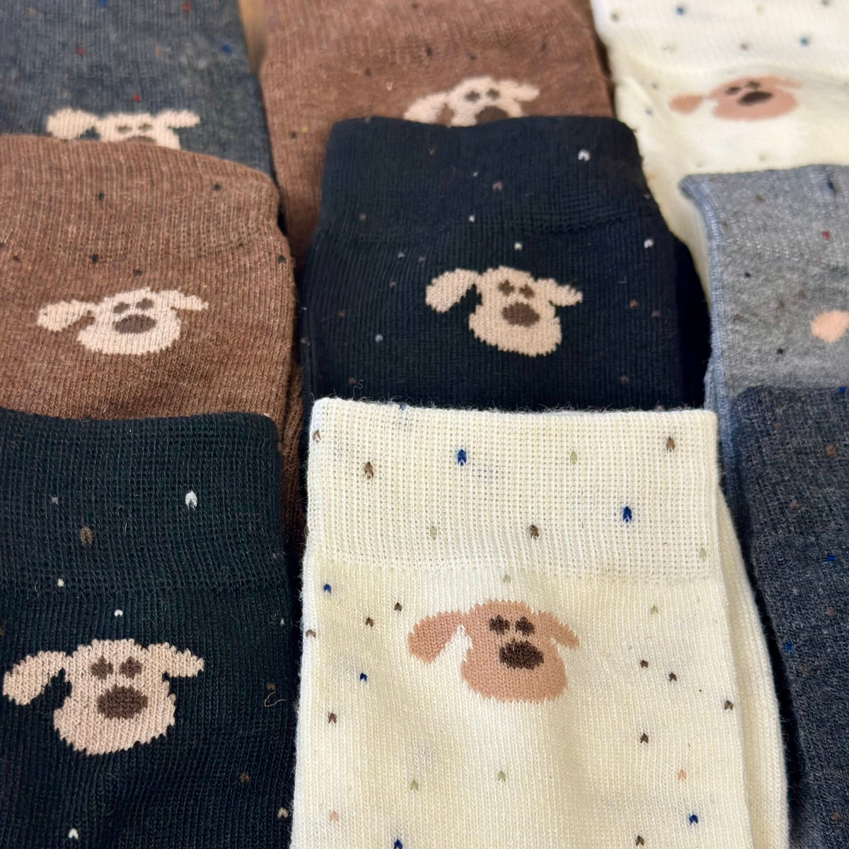 Collection of socks with dog face designs in various colors.