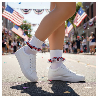 White sneakers with red, white, and blue trim worn on a street with American flags in the background. Patriotic Lace Sock & American Flag Pin Gift Set | Stars & Stripes Cuff Socks