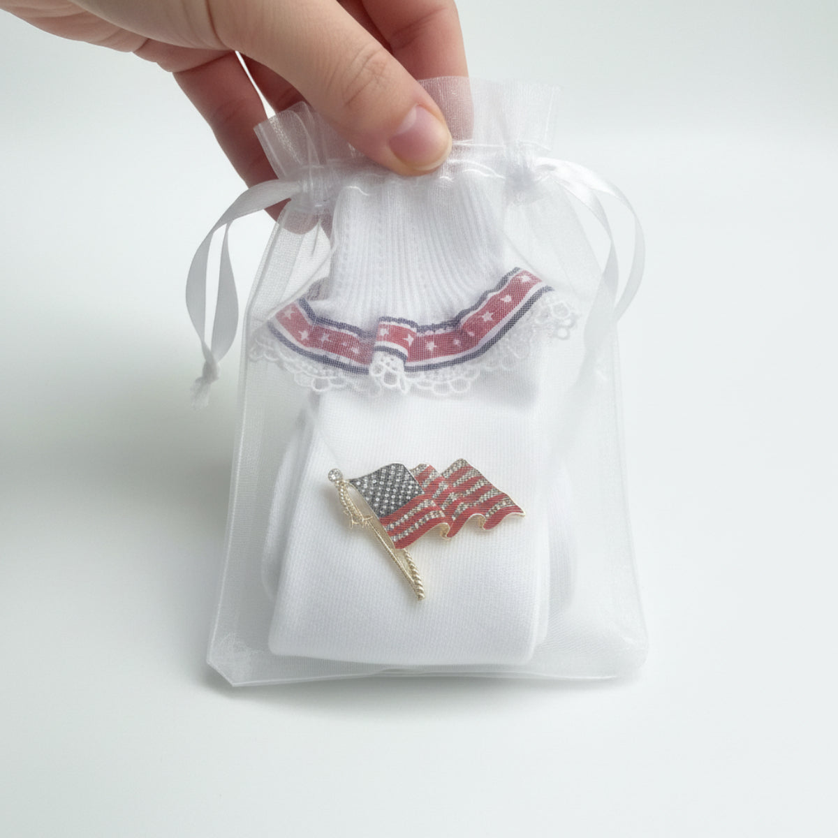 American flag lapel pin on a white shirt with lace details, Patriotic Lace Sock & American Flag Pin Gift Set | Stars & Stripes Cuff Socks