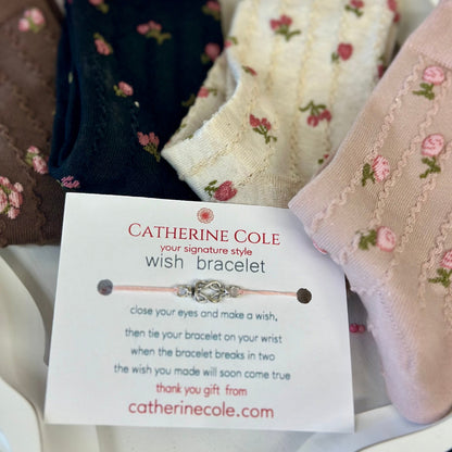 Catherine Cole wish bracelet card with floral-patterned fabric in the background