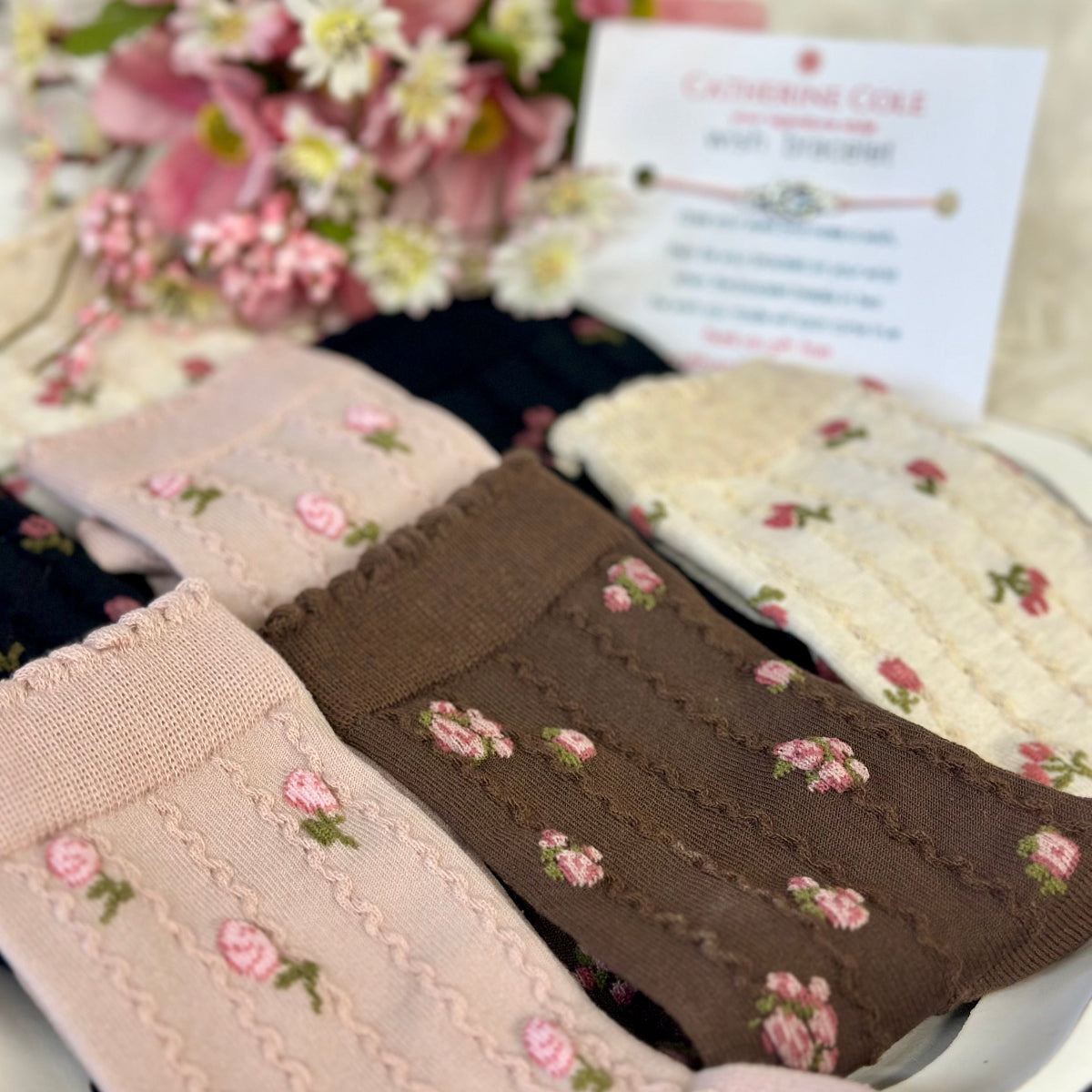 Three floral-patterned ribbons with a blurred background of flowers and text.
