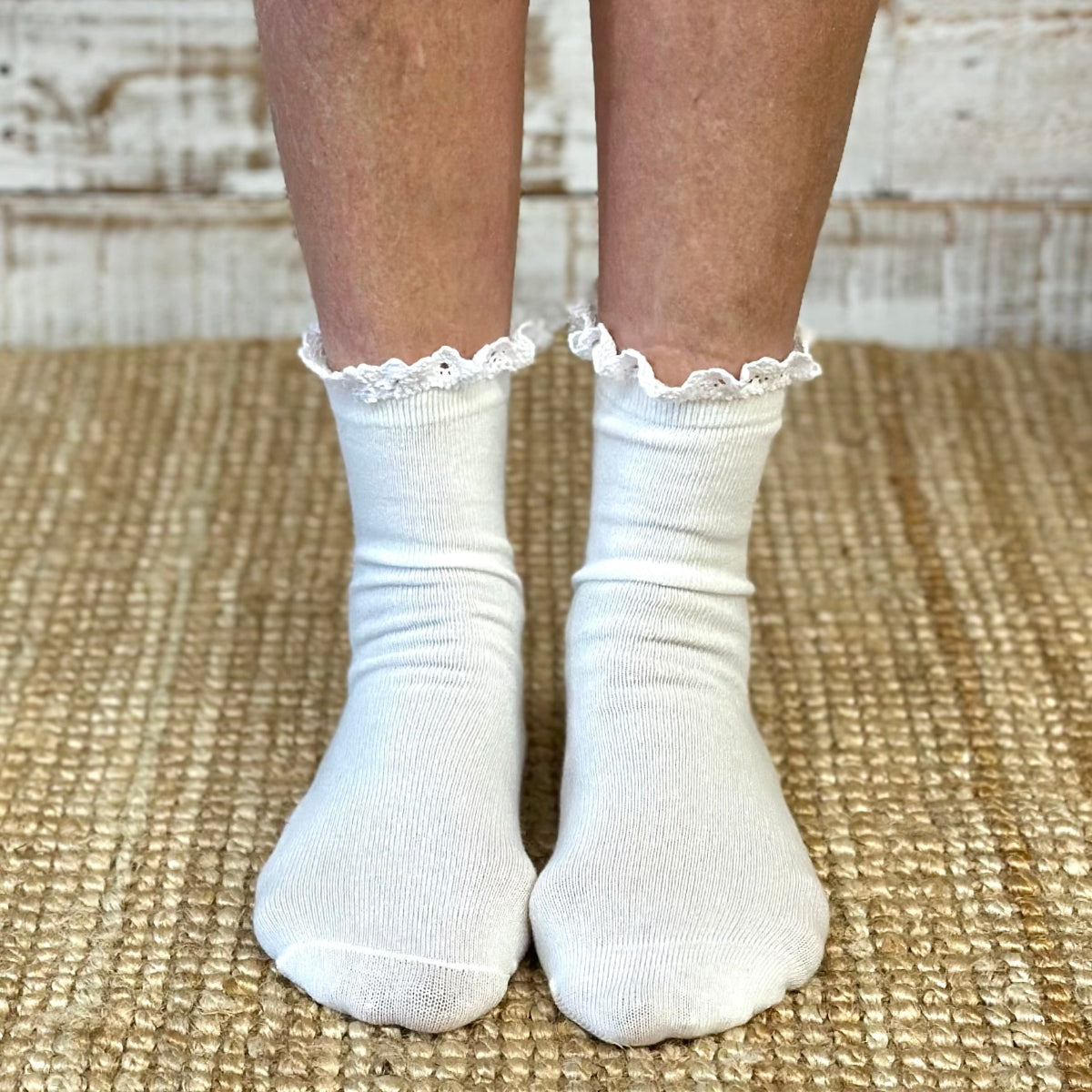 White socks with lace trim worn by a person on a textured surface,  SWEET Lace Top Tube Socks - White