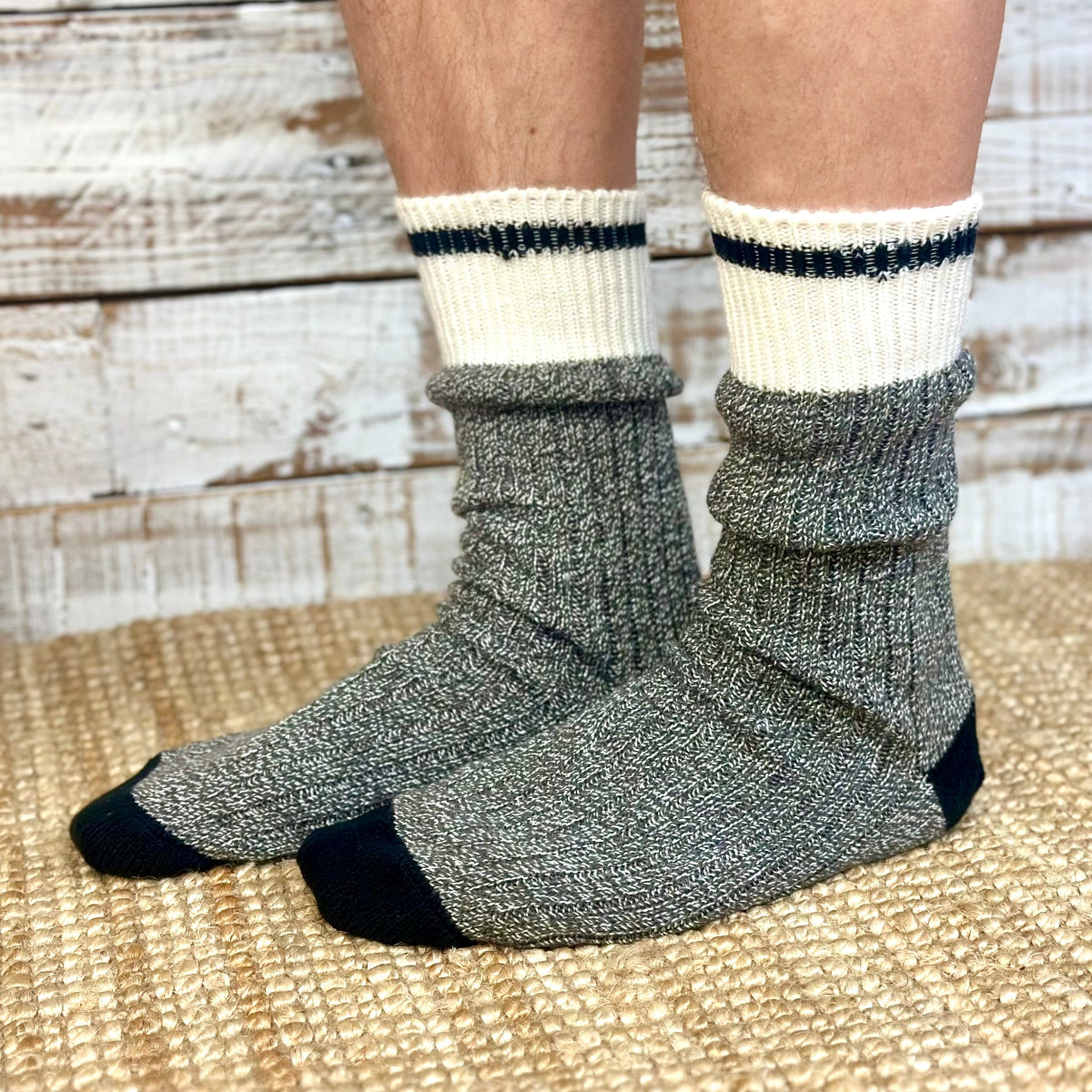 Gray socks with black accents worn by a person on a wooden floor.  Striped Marled Slouch Socks Unisex 10-14 - Salt & Pepper