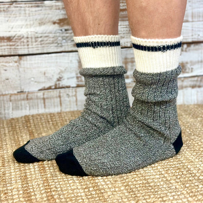 Gray socks with black accents worn by a person on a wooden floor.  Striped Marled Slouch Socks Unisex 10-14 - Salt & Pepper