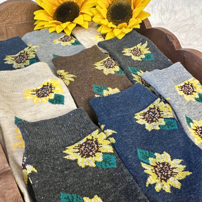 Set of sunflower-patterned socks in various colors on a wooden surface.  Sunflower Patterned Ankle Socks 5-Pack Bundle with Wish Bracelet - Women's 