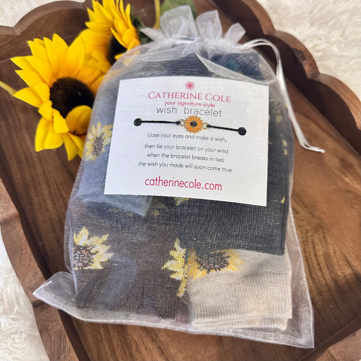 Catherine Cole wish bracelet packaging with a sunflower on a wooden surface