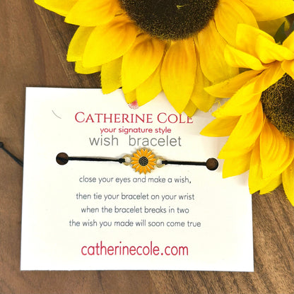 Catherine Cole wish bracelet packaging with sunflowers on a wooden surface