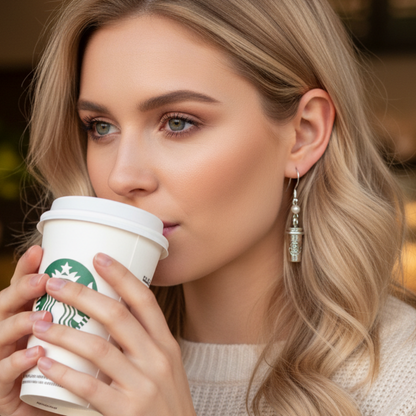 Woman drinking from a Starbucks coffee cup with a blurred background. 
