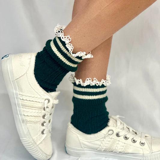 Green and white striped socks with lace trim worn with white sneakers on a light gray background, VARSITY striped crew socks - hunter green Catherine Cole signature socks