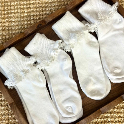 Set of white socks with lace details in a wooden box on a textured surface.  Valued priced 3 pair bundle assorted laces