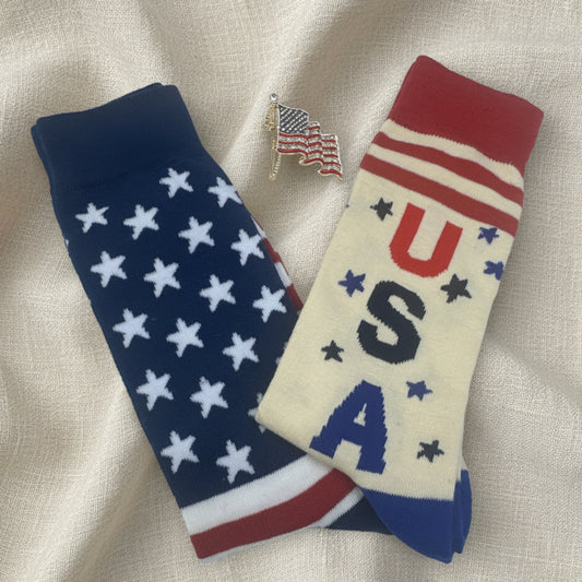 Pair of socks with 'USA' text and American flag design on a white background