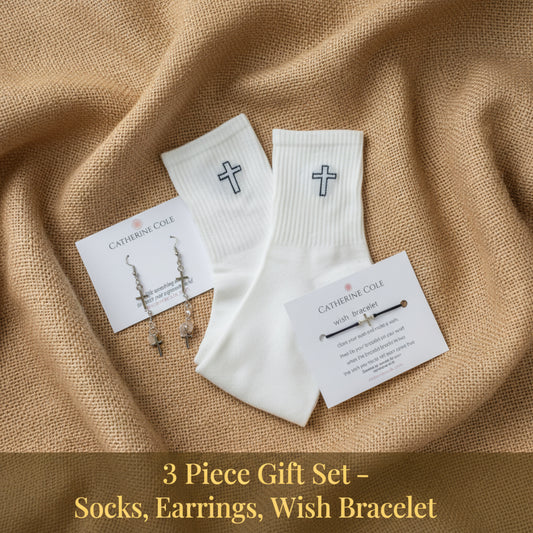 White ribbed knit socks with embroidered crosses, shown with two white product cards on a light beige textured fabric background.