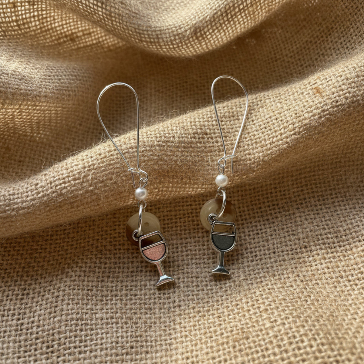 Wine glass earrings on a textured beige fabric background, handmade wine glass earrings for women, girls night out gift