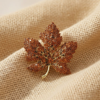 Leaf-shaped brooch on a beige coat. maple leaf rhinestone brooch pin by Catherine Cole