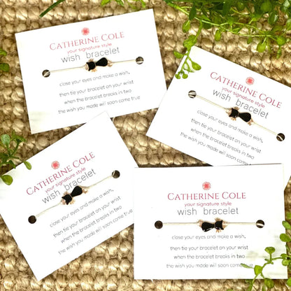 Four Catherine Cole wish bracelets on cards with a natural background
