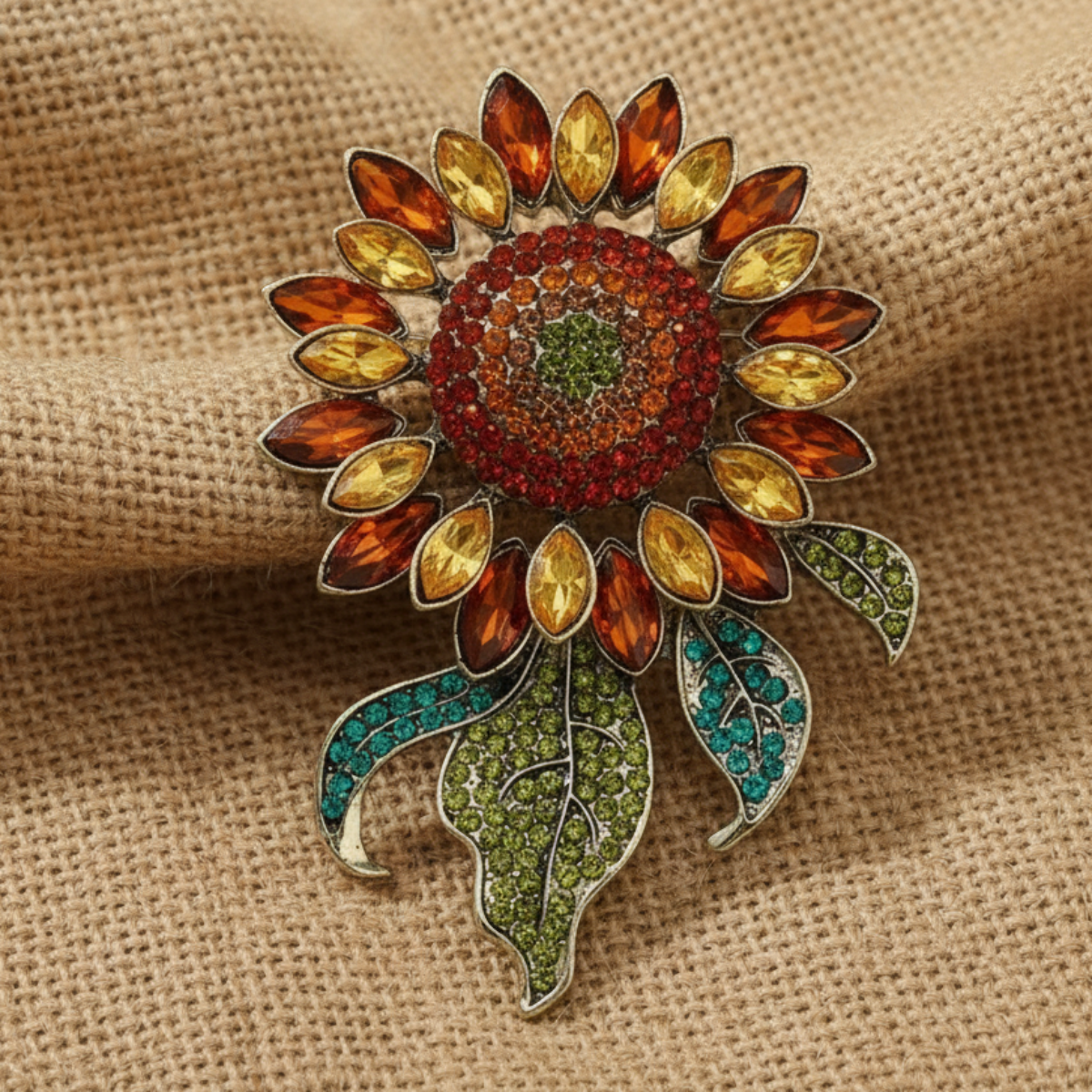 Colorful sunflower-shaped brooch with gemstones on a beige fabric background, Sunflower Crystal Brooch Pin 3x4" | Amber & Teal Rhinestone Brooch