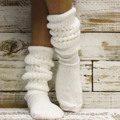 White knitted socks on a wooden background